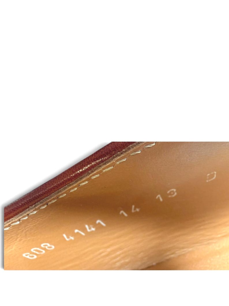 May include: The interior of a shoe featuring a tan leather lining with visible stitching along the top edge. Stamped in white text on the inner side are the numbers 608 4141 14 13 and the letter D, indicating specific product identification.