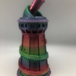 May include: A 3D printed tower with a spiral staircase and a cannon on top. The tower is painted in a rainbow gradient of red, orange, yellow, green, blue, and purple.