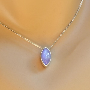 May include: A silver necklace featuring a marquise-shaped, lavender-colored gemstone pendant. The pendant is set in a silver bezel and hangs from a delicate silver chain. The necklace is displayed against a neutral background.
