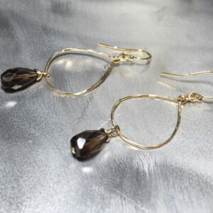 May include: Gold teardrop earrings with faceted smoky quartz stones.
