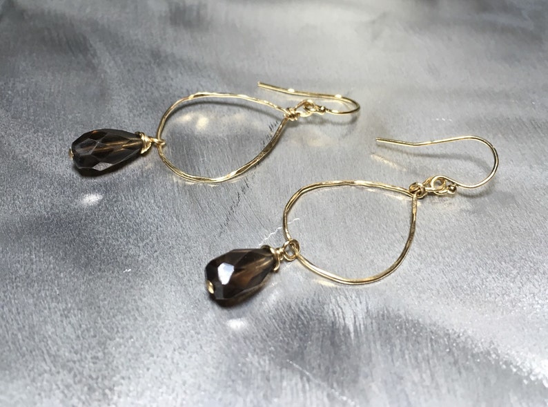 May include: Gold teardrop earrings with faceted smoky quartz stones.