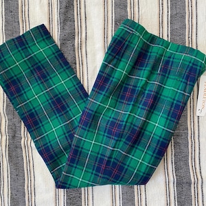 May include: Green and blue plaid pants with a white stripe. The pants have a waistband and a label that says "Pendleton".