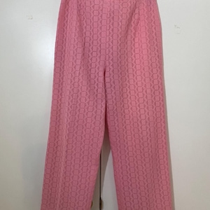 May include: Pink wide-leg pants with a woven pattern.