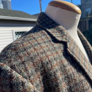 May include: A brown, green and black tweed blazer with a houndstooth pattern.