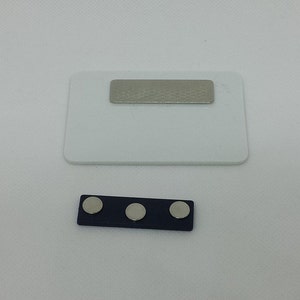 Peut inclure: Une &eacute;tiquette de nom rectangulaire blanche avec un insert en m&eacute;tal argent&eacute;. Une barre noire s&eacute;par&eacute;e avec trois aimants ronds argent&eacute;s.