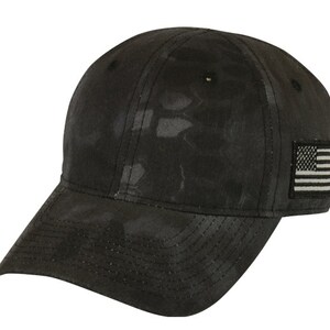 May include: A black camouflage baseball cap with a small American flag patch on the right side.