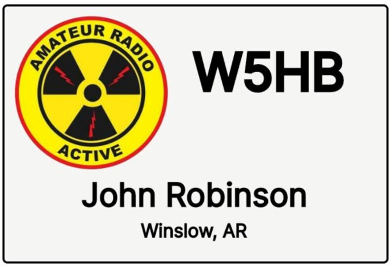 Peut inclure: Une carte blanche avec un cercle jaune contenant un symbole de radiation noir avec des &eacute;clairs rouges. Le texte "Amateur Radio Active" est &eacute;crit autour du cercle. Le texte "W5HB" est &eacute;crit en noir sur le c&ocirc;t&eacute; droit de la carte. Le texte "John Robinson" est &eacute;crit en noir sous le cercle. Le texte "Winslow, AR" est &eacute;crit en noir sous le nom.