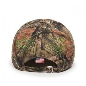 May include: A camouflage baseball cap with a small American flag patch on the back.
