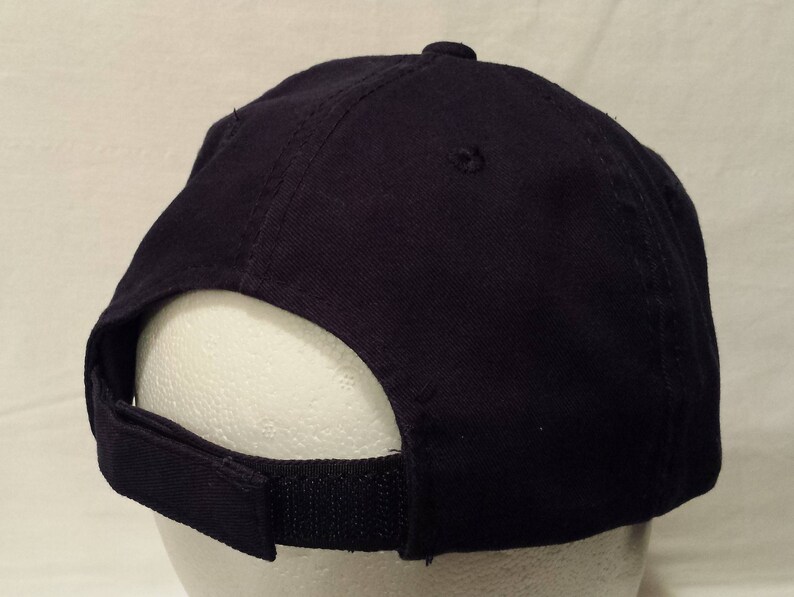 May include: A navy blue baseball cap with a curved brim and adjustable strap. The cap is made of a durable fabric and features a classic six-panel design. The adjustable strap allows for a comfortable fit.