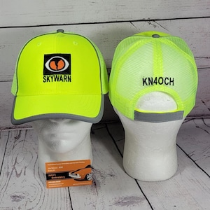 May include: Two neon yellow baseball caps with grey trim. The front cap features a black square patch with an orange eye graphic and the text SKYWARN. The back cap displays the text KN4OCH in black embroidery on the neon yellow mesh back panel.