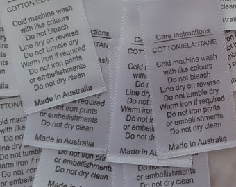 Könnte beinhalten: Ein Stapel weißer Stoffpflegeetiketten mit schwarzem Text. Die Etiketten enthalten Anweisungen zum Waschen, Trocknen und Bügeln von Baumwolle und Elasthan. Der Text auf den Etiketten lautet "Care Instructions COTTON/ELASTANE Cold machine wash with like colours Do not bleach Line dry on reverse Do not tumble dry Warm iron if required Do not iron prints or embellishments Do not dry clean Made in Australia".