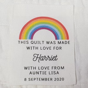 May include: A white label with a rainbow design and the text "This quilt was made with love for Harriet with love from Auntie Lisa 8 September 2020".
