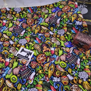 Puede incluir: Tela vibrante con un diseño colorido de temática polinesia. El patrón incluye ilustraciones de kiwis, máscaras tiki, volcanes y otros elementos culturales. Una pequeña caja de madera se encuentra sobre la tela, y una etiqueta dice "RUBYJAM FABRIC".