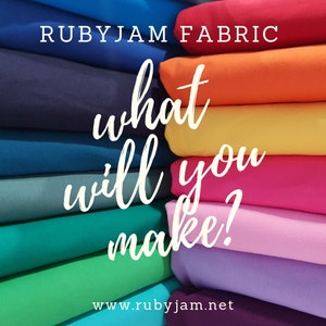 May include: A stack of colorful fabric swatches in various shades of blue, green, purple, pink, orange, and yellow. The text "RUBYJAM FABRIC" is at the top of the image. The text "what will you make?" is written in white cursive over the fabric swatches. The text "www.rubyjam.net" is at the bottom of the image.