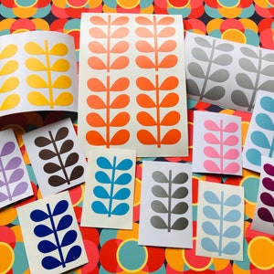 Könnte beinhalten: Ein Set mit 10 Vinyl-Aufklebern mit einem stilisierten Blattdesign in verschiedenen Farben, darunter Gelb, Orange, Grau, Rosa, Blau, Braun, Lila, Türkis, Silber und Burgunder.