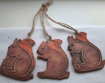 Red squirrels a set of Three handmade ceramic, tree decorations.