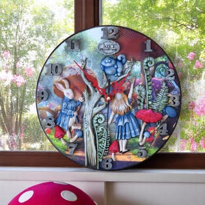 May include: A round Alice in Wonderland themed clock with a 3D design. The clock features Alice, the White Rabbit, and the Cheshire Cat. The clock face is surrounded by mushrooms and ferns.