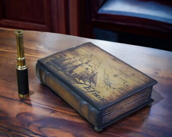 Puede incluir: Una caja de madera de estilo vintage con una tapa encuadernada en cuero. La caja presenta un diseño de mapa náutico con un barco y el texto "Le Francais". También se ve un telescopio de latón.