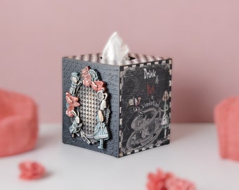 Puede incluir: Caja de pañuelos de madera negra con un patrón de cuadros blancos y negros. La parte delantera presenta una ilustración vintage de Alicia en el País de las Maravillas con el texto "Drink Me Alice in Wonderland".