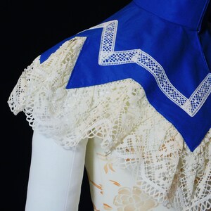 May include: A white lace collar with a blue satin collar underneath. The blue collar has a white lace trim.