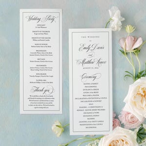 May include: Two wedding ceremony programs with black text on white paper. The left program lists the wedding party, and the right program details the ceremony order. Soft floral arrangements in white and pink are in the background.