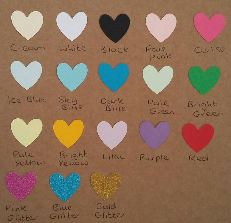 May include: A chart of 15 different colored heart shapes with the color name written below each heart. The colors include cream, white, black, pale pink, cerise, ice blue, sky blue, dark blue, pale green, bright green, pale yellow, bright yellow, lilac, purple, red, pink glitter, blue glitter, and gold glitter.