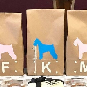May include: Eight brown paper bags with blue and pink silhouette images of miniature schnauzers. Each bag has a letter printed on the front: B, F, K, M, D, H.