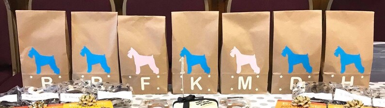 May include: Eight brown paper bags with blue and pink silhouette images of miniature schnauzers. Each bag has a letter printed on the front: B, F, K, M, D, H.