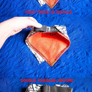 Pode incluir: Um bandana estampado em branco e preto com forro de l&atilde; vermelho. O bandana tem uma al&ccedil;a ajust&aacute;vel preta com uma fivela de metal. A al&ccedil;a &eacute; passada duas vezes pela fivela para garantir o bandana.