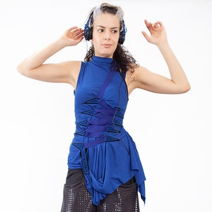May include: A woman wearing blue headphones and a blue sleeveless top with a black and blue design. The top has a criss-cross detail at the front. She is wearing a black skirt with a mesh overlay.