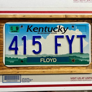 May include: A Kentucky license plate with the number 415 FYT and the word "FLOYD" printed below. The plate is framed in a wooden frame.