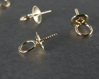 May include: Four gold-toned metal jewelry findings with a loop and a pin. The findings are designed for attaching to jewelry pieces.