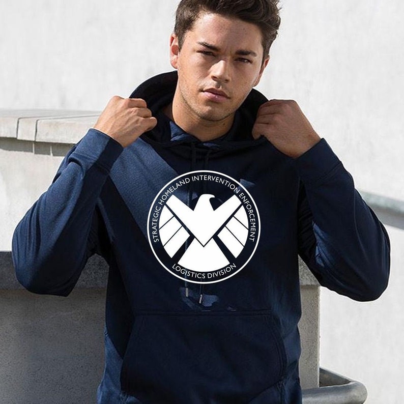 May include: A navy blue hoodie with a white logo featuring a falcon and the text "Strategic Homeland Intervention Enforcement Logistics Division".