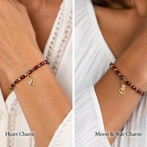 May include: Two beaded bracelets featuring alternating dark red and metallic silver beads. The left bracelet includes a gold-toned heart charm with a small clear stone, while the right bracelet features a gold-toned moon and star charm with a clear stone.