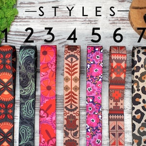 May include: Seven different styles of camera straps, numbered 1 through 7. The straps are made of fabric and feature various colourful patterns, including geometric, floral, and animal print designs.