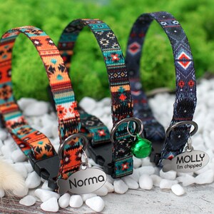 May include: Three colorful cat collars with a geometric pattern. The collars have a metal tag with the names "Norma" and "Molly I'm chipped" engraved on them.