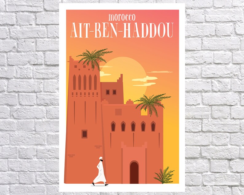 May include: A colorful illustration of a traditional Moroccan building with a person walking in front of it. The building is made of red brick and has a tall tower with windows. The sky is orange and yellow, and there are palm trees in the foreground. The text "MOROCCO A&Iuml;T-BEN-HADDOU" is at the top of the image.