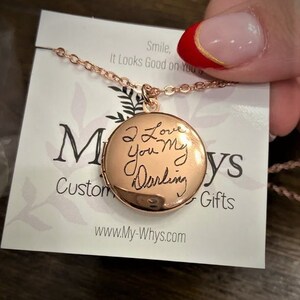 May include: A gold locket necklace with a handwritten message that reads "I Love You My Darling". The necklace is on a white card with the text "Smile, It Looks Good on You" and "Custom Gifts".