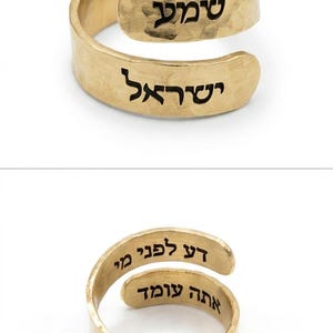 May include: A gold-colored wrap ring with a hammered texture. The top image shows the outside engraving with the Hebrew text "שמע ישראל". The bottom image shows the inside engraving with the Hebrew text "דע לפני מי אתה עומד". The ring has an open design.