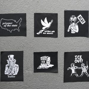May include: Six black patches with white graphics and text. Designs include a map of the USA with "prisoner of the state", a dove with "neither god nor master", a figure with "ACAB", a skeleton with "Suffer", a box with "ICE DEFUND", and figures with "ICE OUT!"