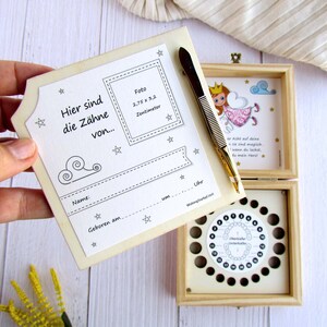 May include: A wooden box with a tooth fairy theme. The box has a compartment for storing baby teeth and a chart to track when each tooth falls out. The box also includes a small pair of tweezers and a space for a photo. The text on the box reads "Here are the teeth of..." and includes space to write the child's name and birthdate.