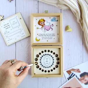 May include: A wooden box with a tooth fairy illustration on the lid. The box has a chart inside for storing baby teeth. The text on the lid reads "Always take care of your teeth. Remember that they are magical. Every time you smile, you warm my heart."