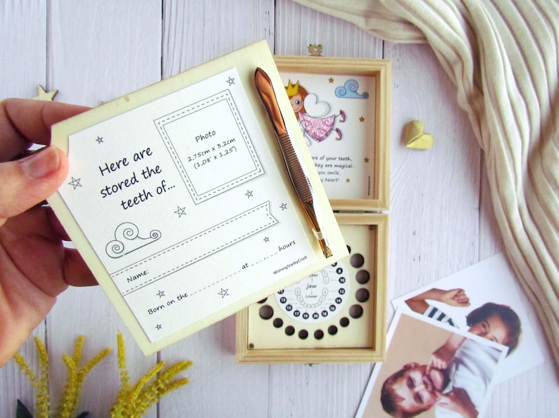 May include: A wooden box with a white background and a small fairy illustration. The box has a compartment for storing baby teeth and a space for a photo. The text on the box reads "Here are stored the teeth of..." and includes a space for the child's name and birth date.