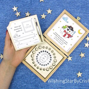 May include: Wooden box with a tooth fairy theme. The box has a compartment for storing baby teeth and a removable lid with a space for a photo and information about the child. The lid also has a quote about taking care of teeth. The box is decorated with stars and a moon.