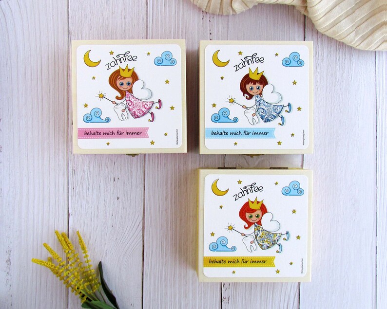 May include: Three wooden boxes with a tooth fairy theme. Each box features a different tooth fairy illustration with a tooth, a wand, and clouds. The text on the boxes reads "Zahnfee" and "behalte mich f&uuml;r immer".