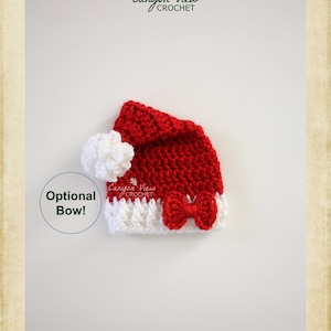 May include: Red and white crocheted Santa hat with a white pom-pom and a red bow. The hat is on a white background. Optional Bow! Canyon View Crochet.