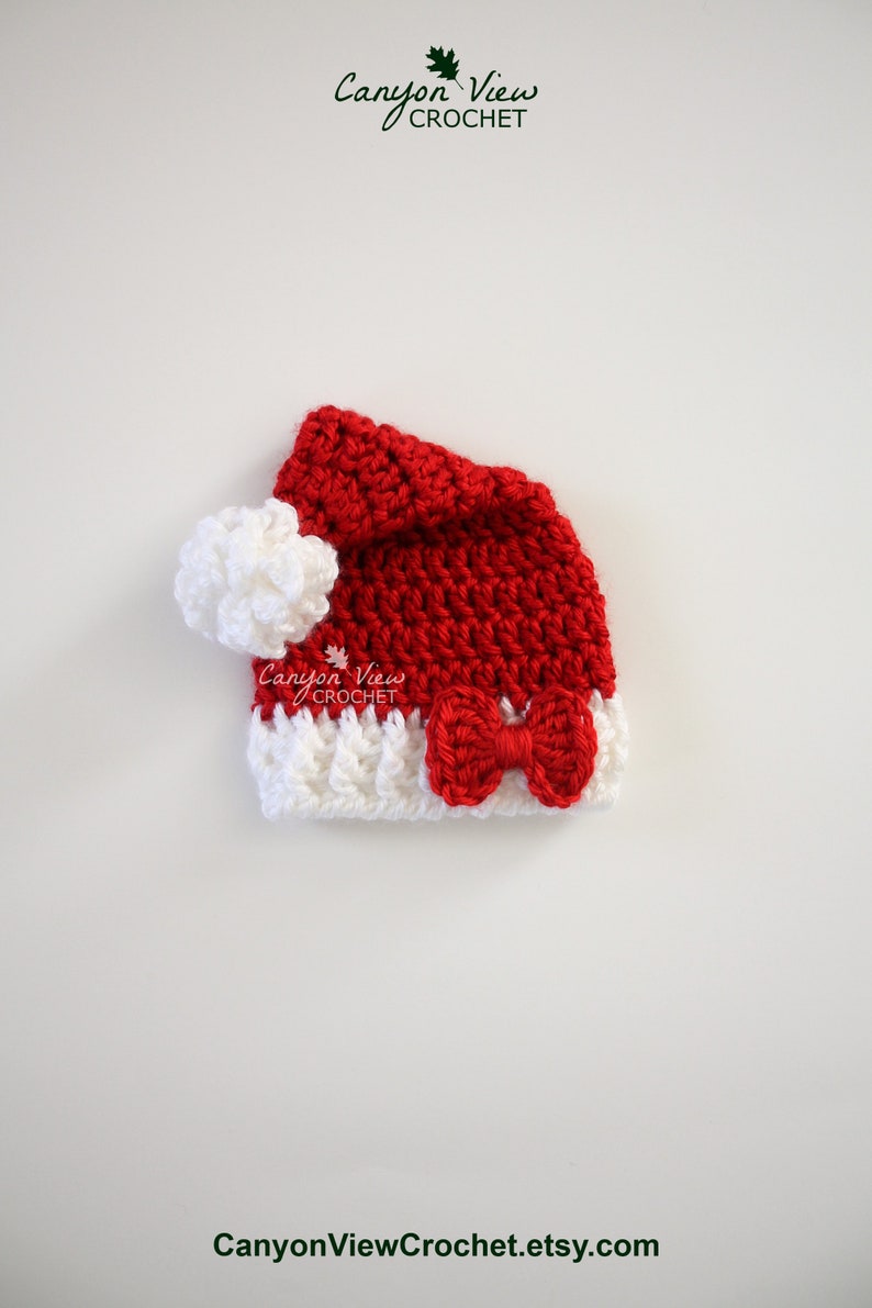 May include: A red and white crocheted Santa hat with a white pom-pom and a red bow. Canyon View Crochet.