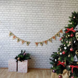 May include: A festive Christmas scene with a decorated tree, gift boxes, and a banner that reads "FELIZ NAVIDAD." The tree is adorned with red bows, ornaments, and decorative accents. Gift boxes are wrapped in pink paper with a flamingo pattern.