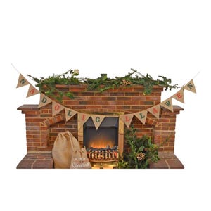May include: A brick fireplace decorated for Christmas with a banner that reads "Nostalgia". A burlap sack and a smaller sack with the word "Christmas" are in front of the fireplace. The fireplace has a faux fire.