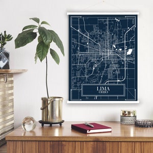 May include: A navy blue map print of Lima, Ohio, with white lines showing the streets and a white border. The city name is written in white text at the bottom of the map.